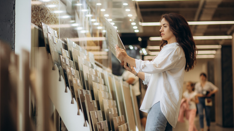 Woman looking at tile samples at home improvement store