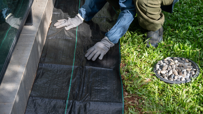 placing landscape fabric against wall ready to cover in gravel