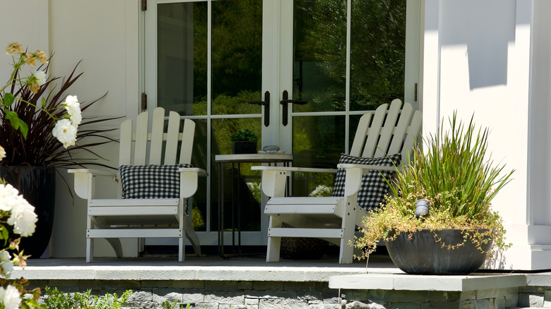French doors leading to two chairs on a front porch