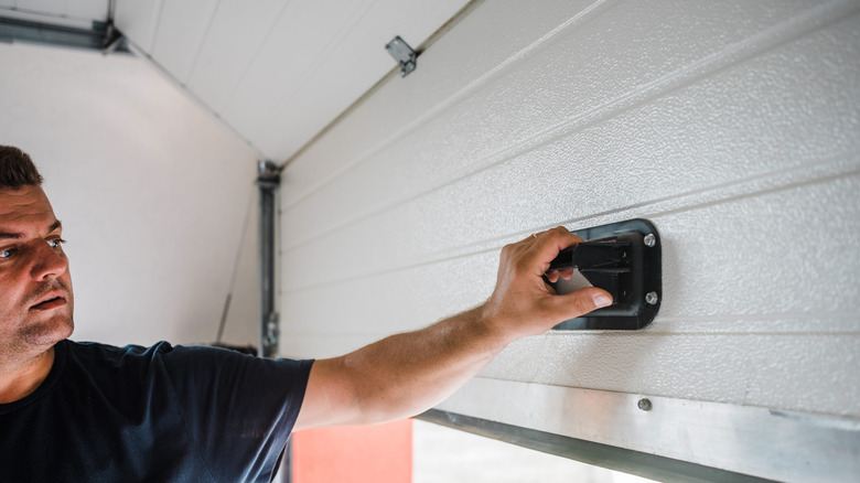 Person lifting garage door by the inside handle