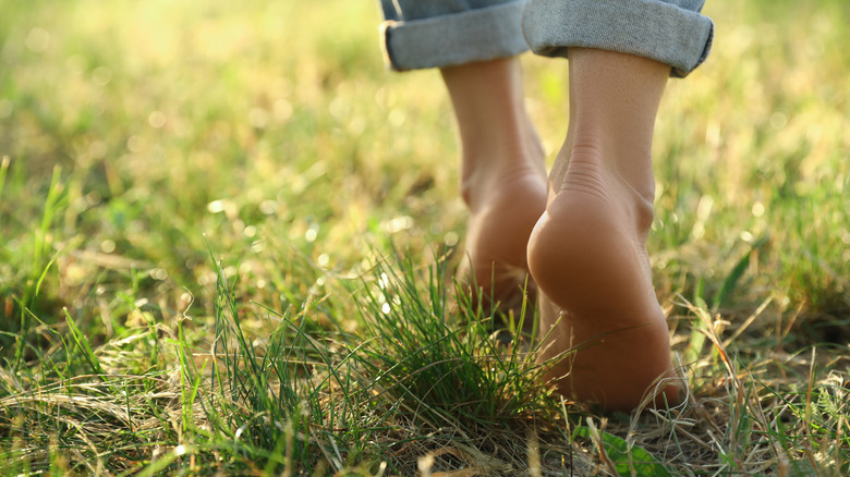 Woman walks barefoot in grass