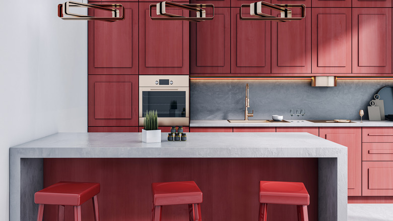 kitchen with red wood cabinets and concrete island and countertop