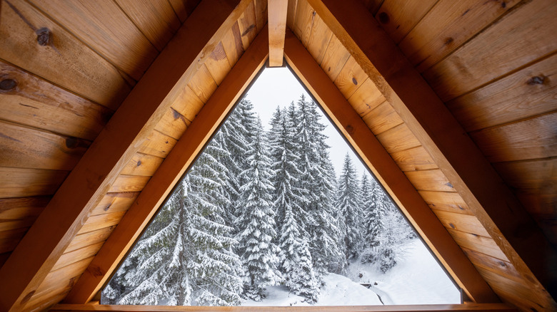 A winter snow scene is visible through a triangular attic window