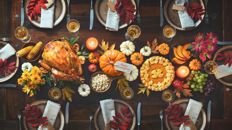 thanksgiving table with plates and foliage 