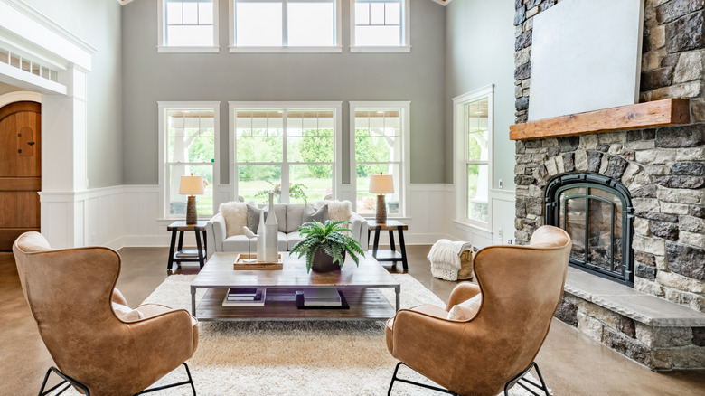 A living room features a large stone fireplace