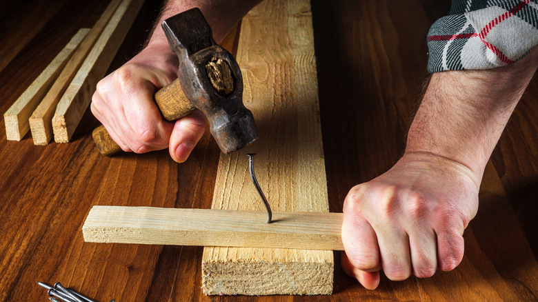 Hammering bent nail into wood
