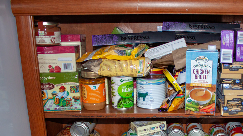 A pantry is cluttered with various items.