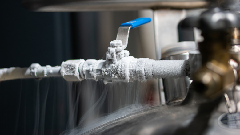 A pipe with an opening valve covered in a thick layer of ice