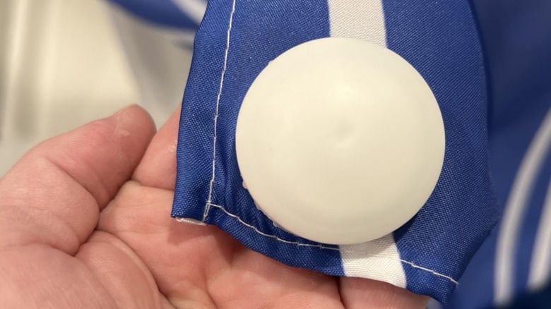 Person holding a shower curtain with a white magnet on it