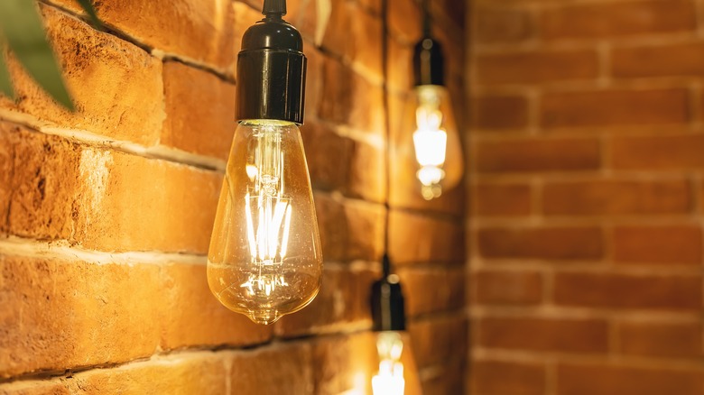 Light bulb that is lit hanging in light fixture