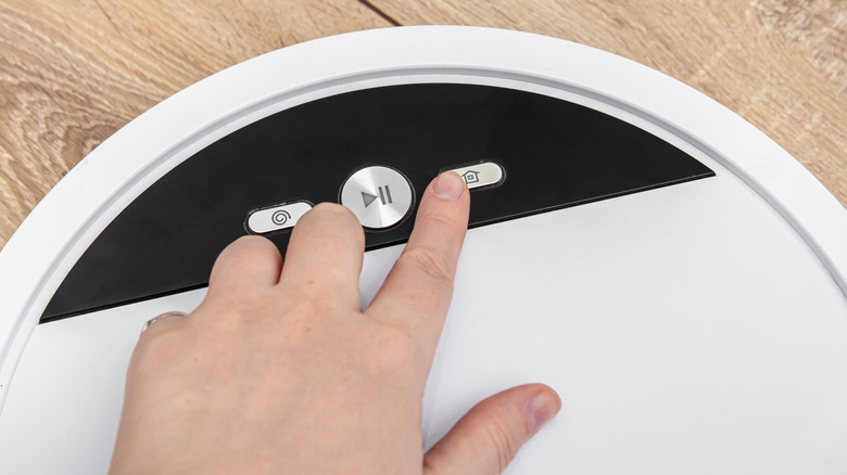 Pressing the home button on a robot vacuum