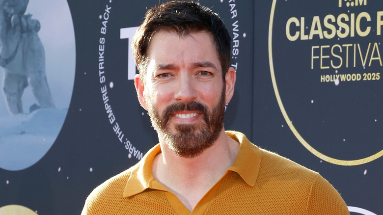 Drew Scott smiling on red carpet.