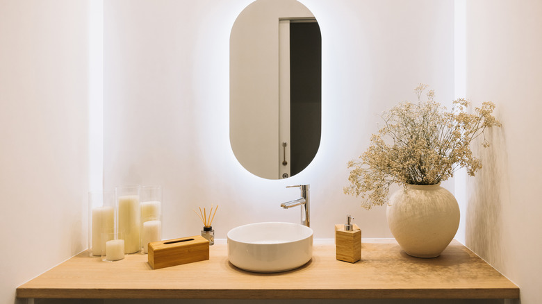 A modern, minimalist bathroom vanity with a round sink.