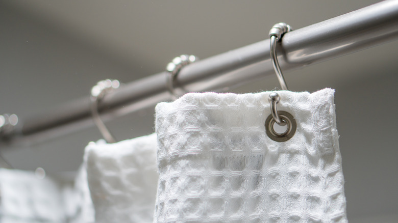 white shower curtain on rod