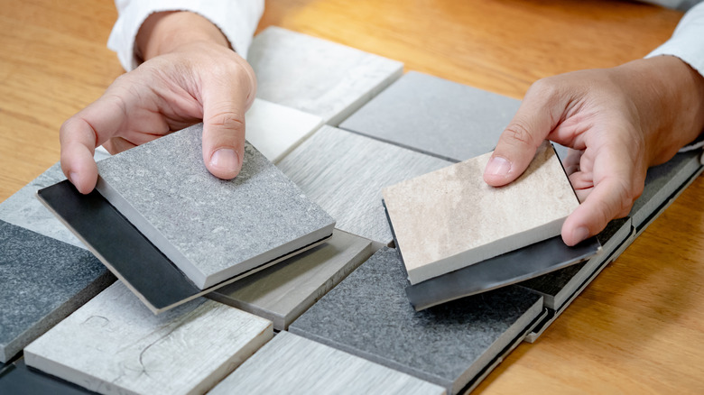 Person holding up tile samples