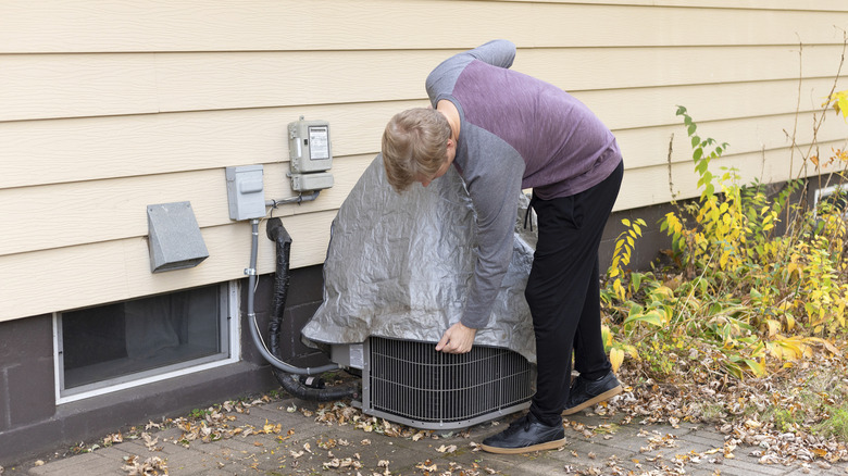 person partially covering their ac unit
