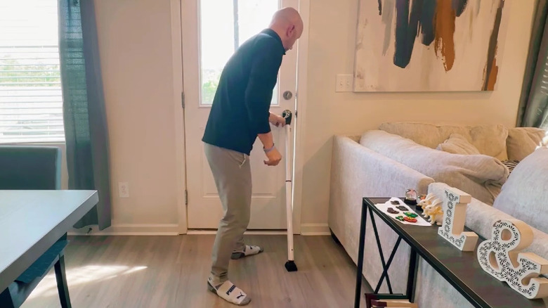 Man placing AceMining security door bar under the knob of a door.