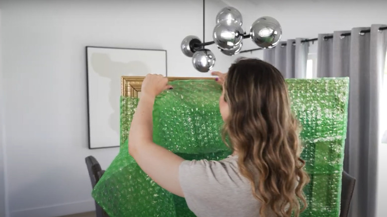 A woman packing a picture for moving