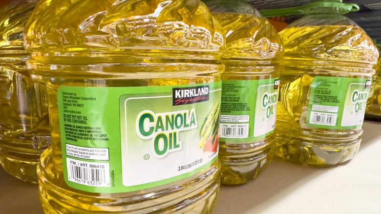 Several bottles of Canola oil on a shelf