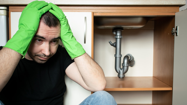 Man next to broken plumbing