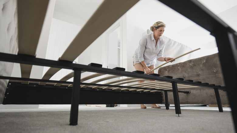 Woman adding slats to bed frame