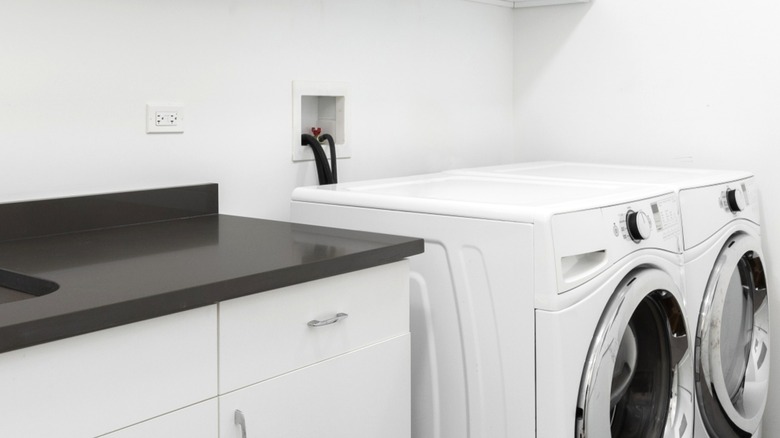 Exposed washer hookup behind front-load laundry set