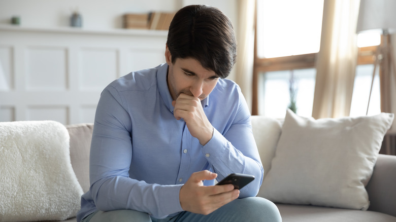 seated man browsing smartphone