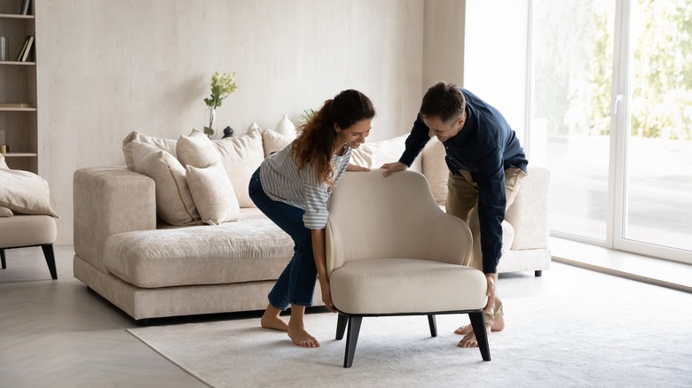  smiling couple moving furniture
