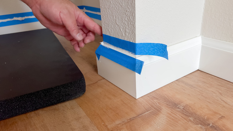A person peeling away blue painter's tape