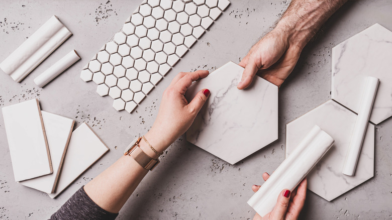 hands with tile samples