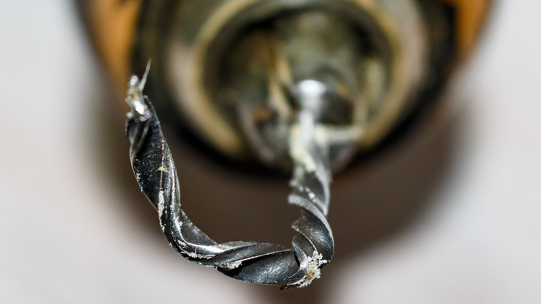 A close up of a drill with the drill bit bent and twisted