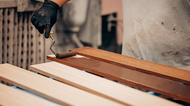 workman staining a piece of wood