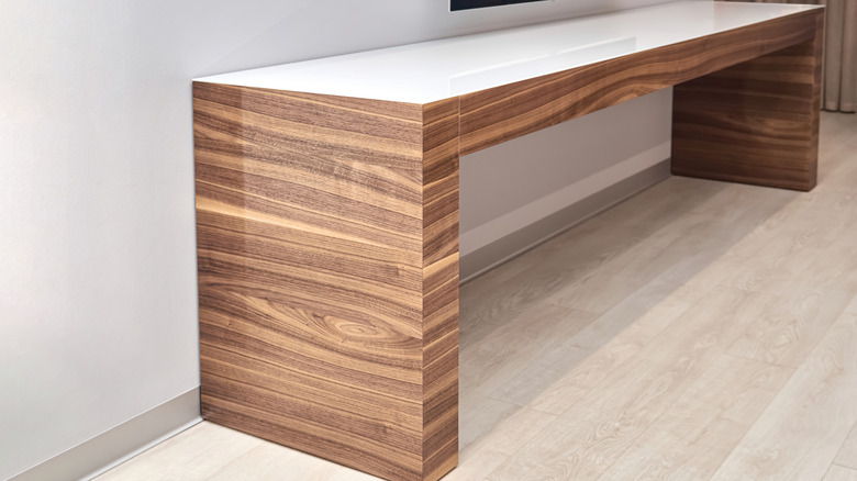 A TV console with a wood veneer finish