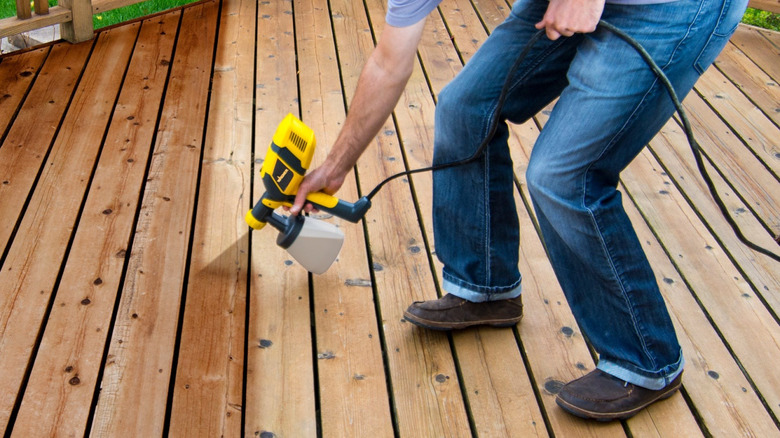A person using the Wagner QX2 to add a stain onto a deck