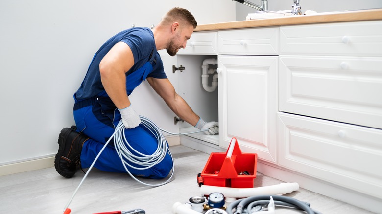 plumber working under kitchen sink