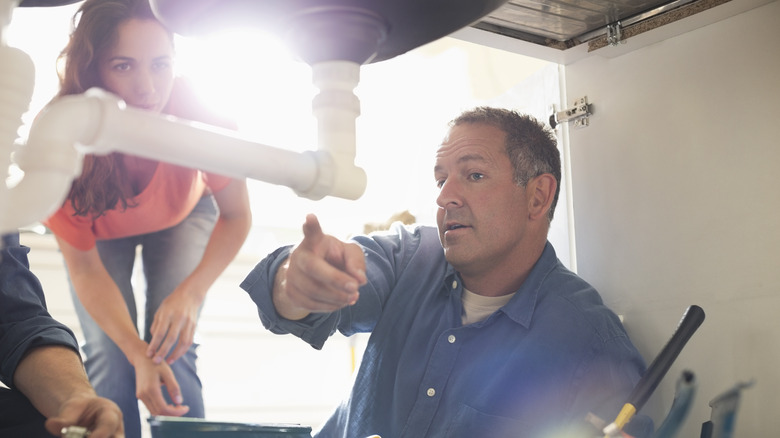 plumber pointing out issue to client