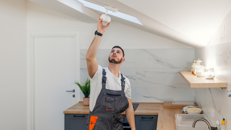 electrician checking lighting in kitchen