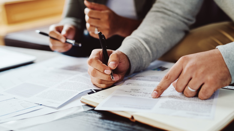 hands signing paperwork