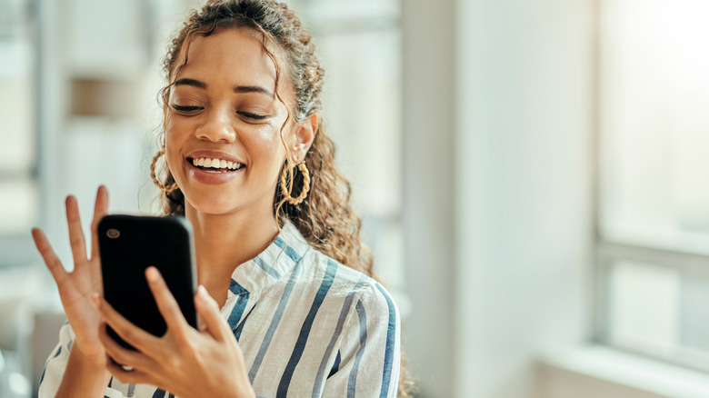 woman smiling and texting