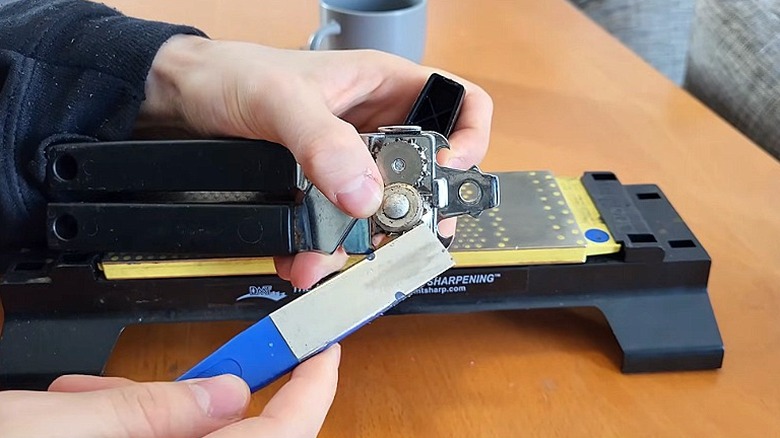 Person sharpening a can opener with a metal file