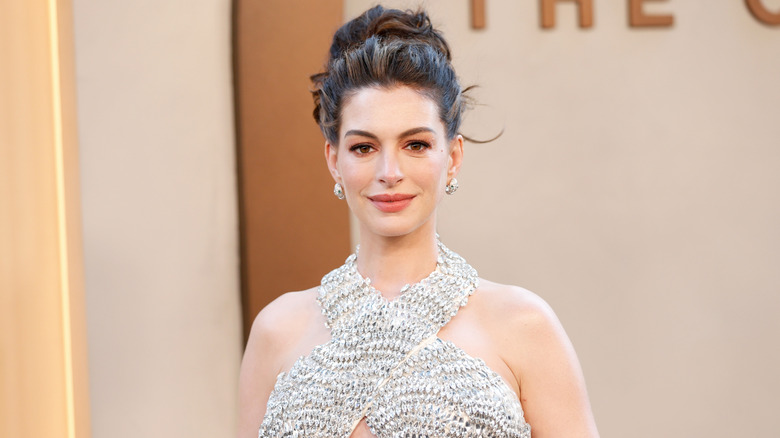 Anne Hathaway poses for a photo in a bejeweled dress.