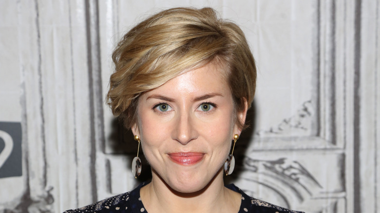 Erin Napier smiling with gold and shell-colored earrings
