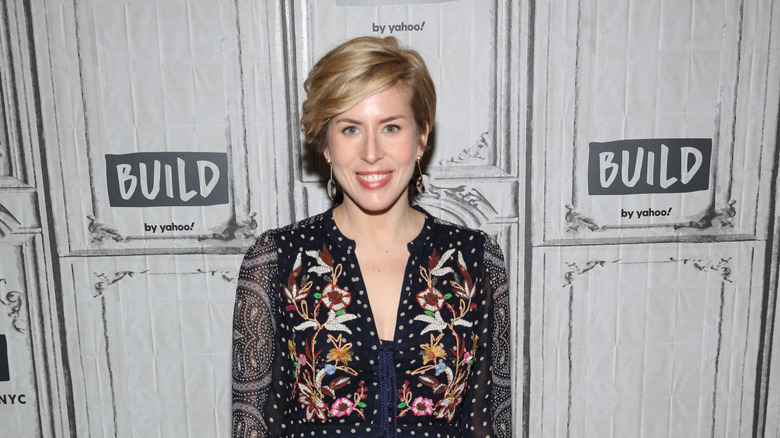 Erin Napier smiling in a black floral shirt at an event
