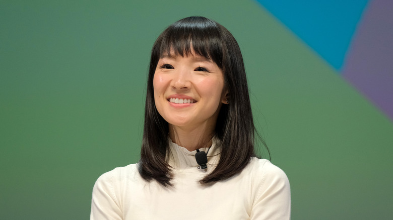 Marie Kondo smiles against a green background