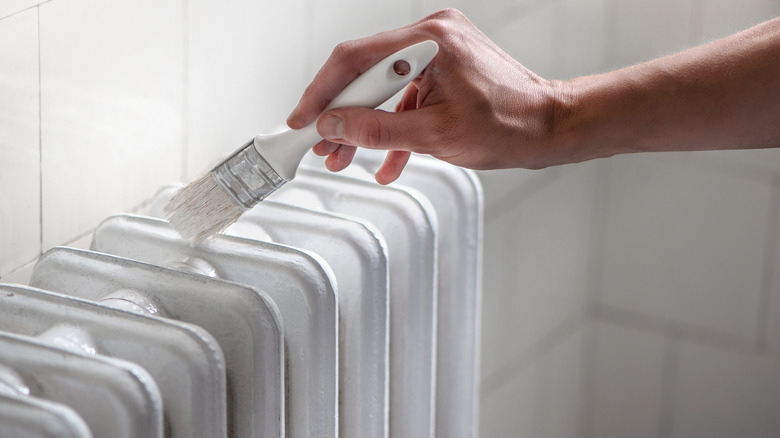 Person painting radiator white