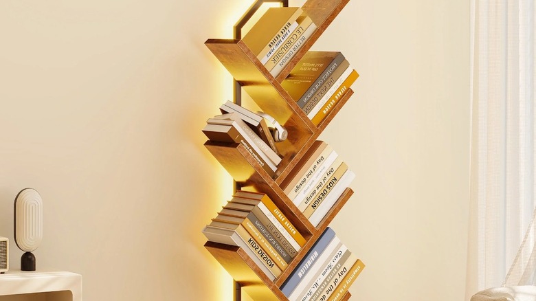 A tree-style lit up bookshelf in a room