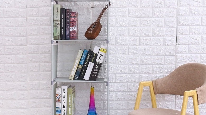 Gray-colored shelves of a bookcase holding novels and decor items