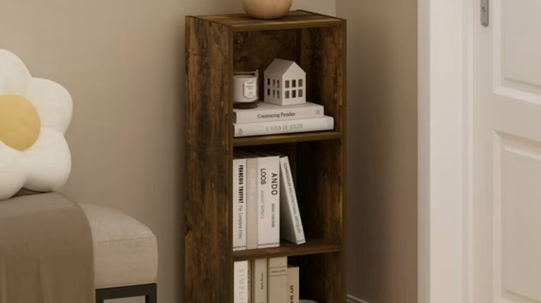 A small brown bookshelf in the corner of a room