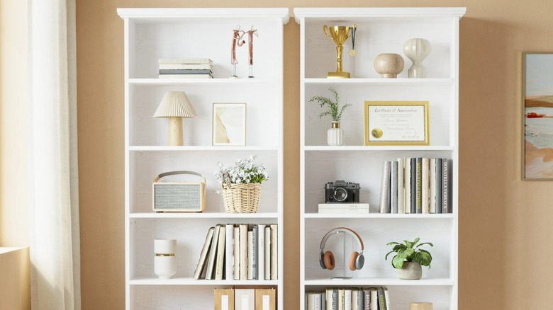 Two white bookshelves placed side-by-side in a room