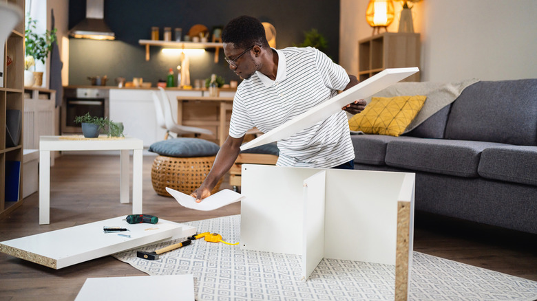 Man assembling a bookcase at his home